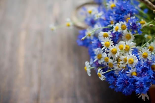 Korenbloemen en kamille op houten achtergrond