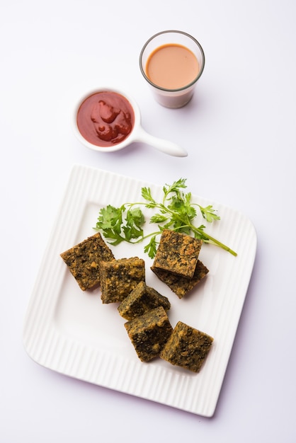 Koriandercake of Kothimbir Vadi is een populaire maharashtrische keuken gemaakt met korianderbladeren. geserveerd met tomatenketchup. selectieve focus