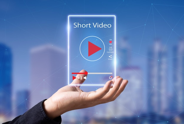 Foto kort videomarketingconcept man handen met virtuele korte videospeler met wazige stad als achtergrond