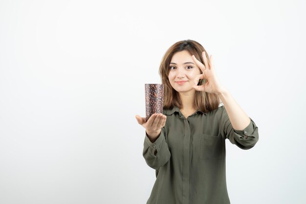 Kortharig jong meisje met kopje latte over witte muur. Hoge kwaliteit foto