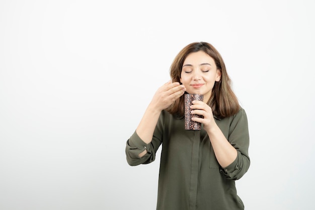 Kortharig jong meisje met kopje latte staan en poseren. Hoge kwaliteit foto