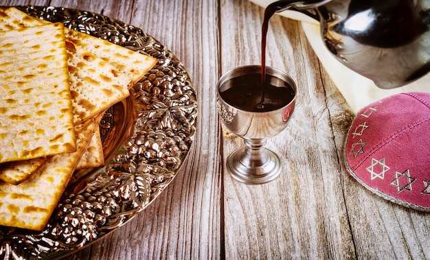 Kosher kiddush, matza and kippa on wooden surface