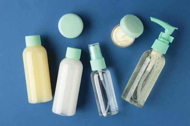 Kosmetische reisflessen op donkerblauwe achtergrond Minimalistische schoonheidsproducten voor lichaamsverzorging voor vakantie of reis