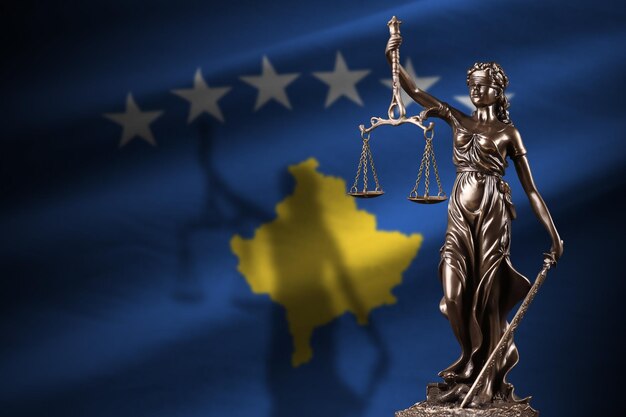 Kosovo flag with statue of lady justice and judicial scales in dark room Concept of judgement and punishment