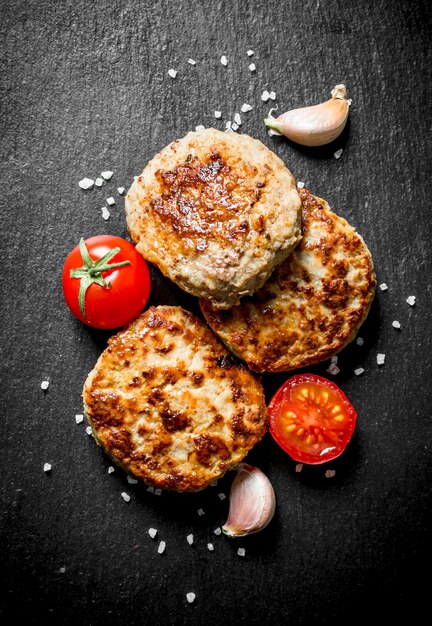 Koteletten met knoflookteentjes en tomaten