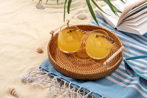 Koude ananascocktails op een rieten dienblad op strand met wit zand Zomervakantie op zee en reisconcept Exotische zomerdrankjes