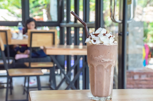 Koude cacao met slagroom op een houten tafel