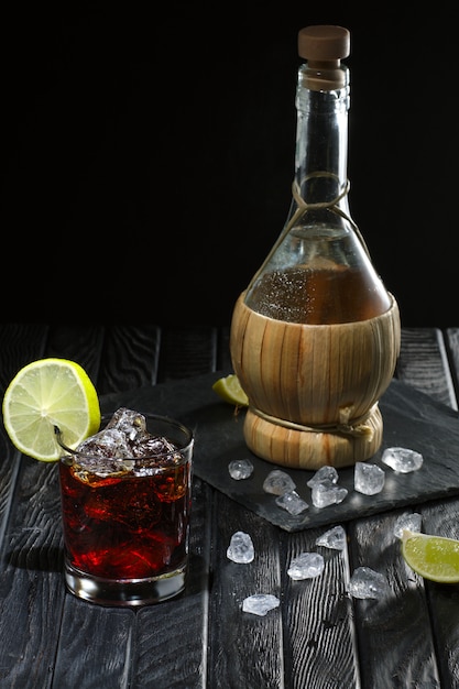 Koude cocktail met wodka, limoen en koffielikeur en de fles