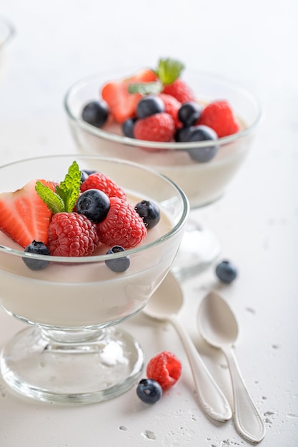 Koude en heerlijke Panna Cotta geserveerd in glas met bessen