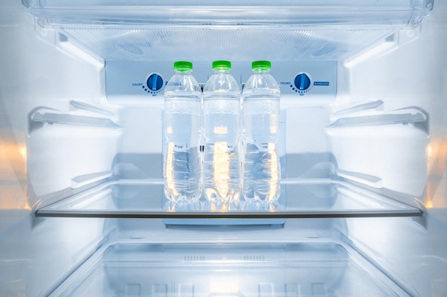 Koude flessen schoon drinkwater in een witte koelkast