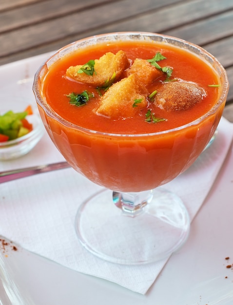 Koude gazpacho met knoflookcroutons in glazen kom