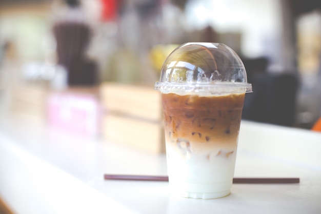 Koude koffie in plastic beker op een houten tafel in café