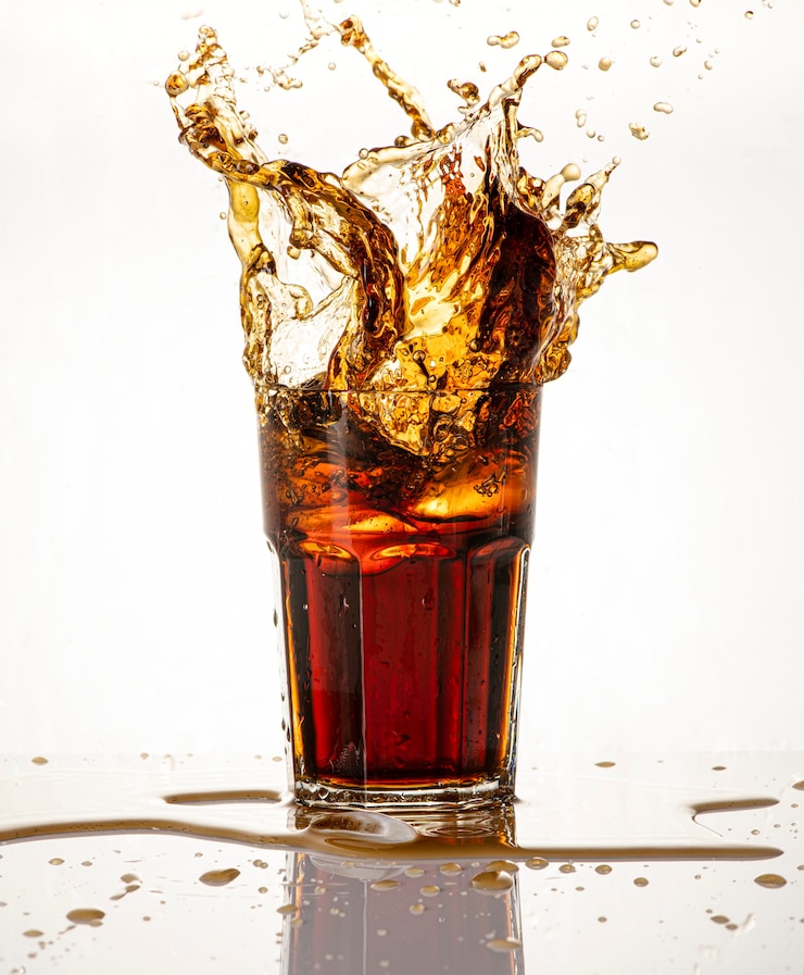 Foto koude koolzuurhoudende drank spettert over het glas