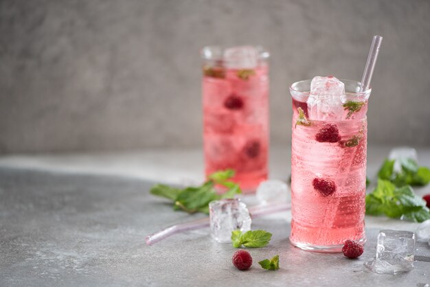 Koude limonade met verse frambozen en munt in hoge glazen