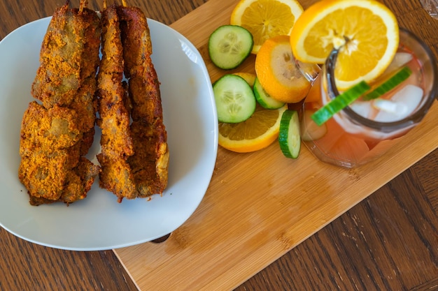 Koude nigeriaanse chapman-cocktail geserveerd met suya nigeriaanse peperrundvlees