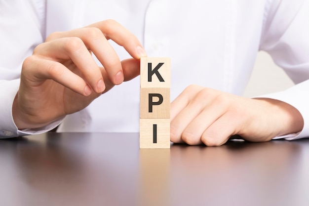 KPI Key Performance Indicator-tekst op kubusblokken in zakenman handen man in wit overhemd
