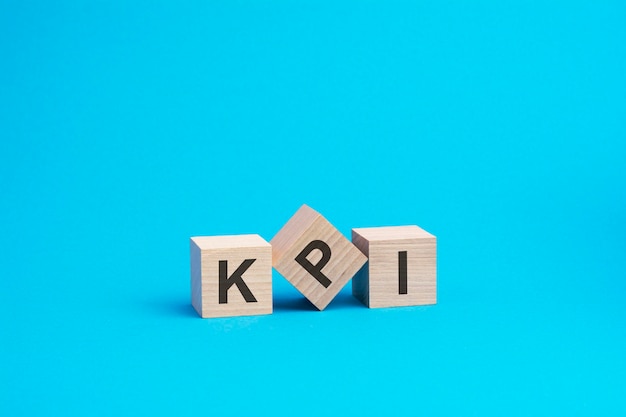 Фото Текст kpi на деревянных блоках бизнес-концепция синий фон