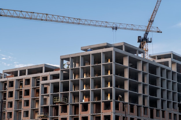 Kraan en een gebouw in aanbouw tegen een blauwe achtergrond