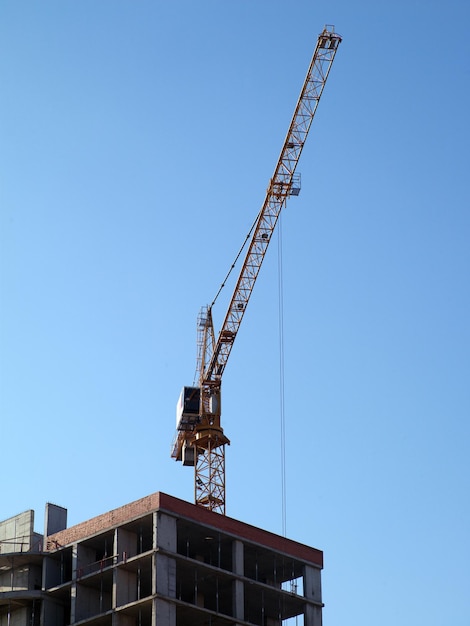 Kraan in het werkproces op blauwe hemelachtergrond