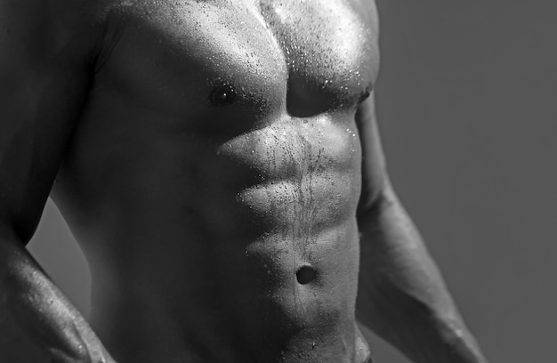 Kracht atletische man met perfecte spieren abs blote naakte borst op donkere achtergrond