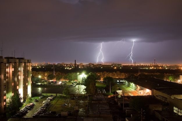 Krachtige bliksemflits verlicht de nachtelijke hemel en de stad