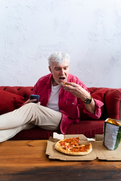 Foto krachtige opa die pizza eet en ontspant