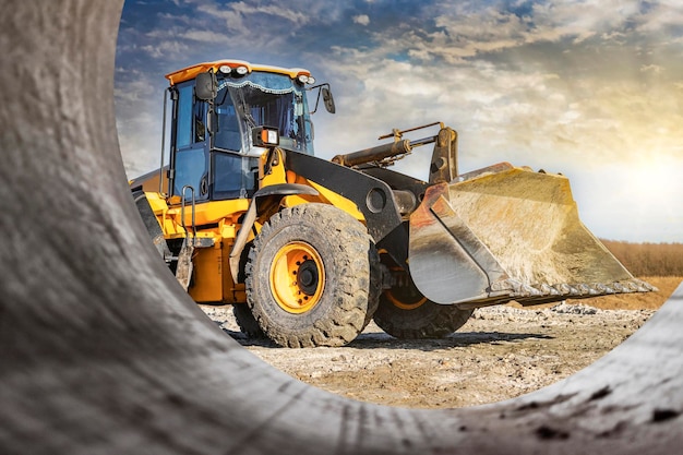 Krachtige voorwiellader of bulldozer die werkt aan een steengroeve of bouwplaats grondwerken in de bouw Krachtige moderne apparatuur voor grondwerken