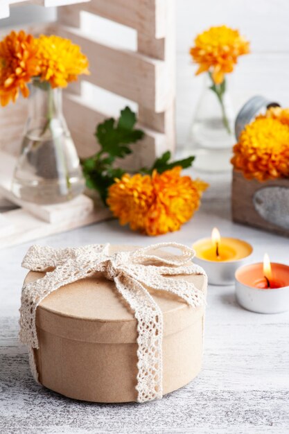 Kraft geschenkdoos en oranje bloemen in glazen pot