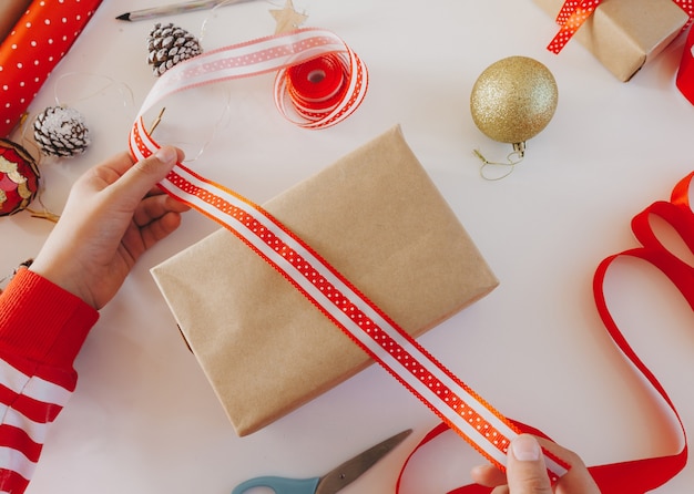 Kraft paper gift boxes with red ribbon. view from above. phased gift wrapping. New Year. Flat lay