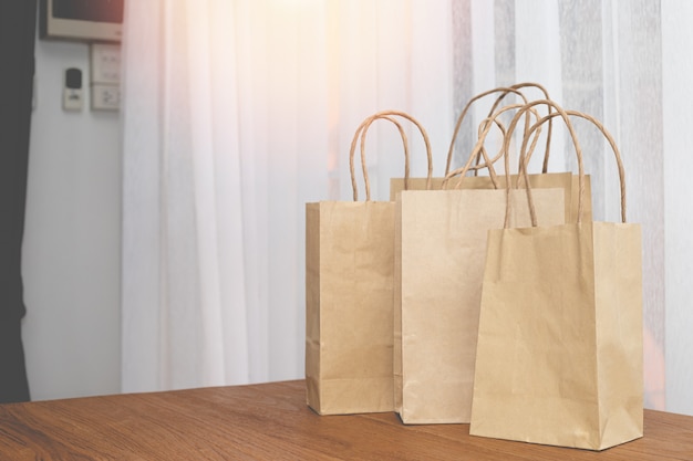 Kraft paper shopping bags on wood table.