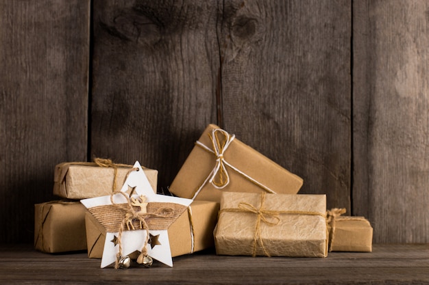 Kraftpapier-geschenken en een kerststerdecoratie op een oud houten boekenrek.