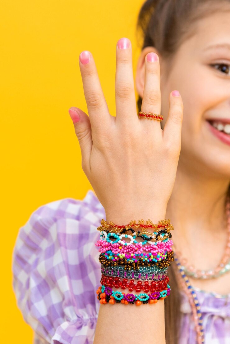Kralen armbanden op de handen van een klein meisje veelkleurige sieraden op zijn handen kralen voor kinderen