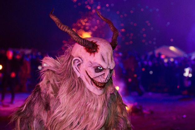 krampus dressed in eerie face masks illuminated by a fire in the night