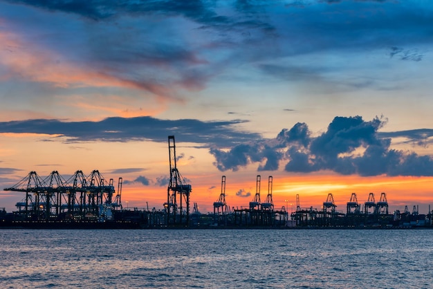 Kranen in de haven tegen de hemel bij zonsondergang