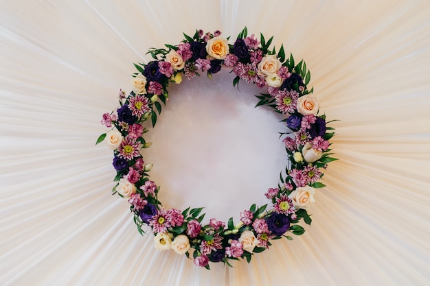 Krans gemaakt van prachtige kleurrijke bloemen op een witte tafel