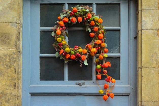 Krans van herfstplanten met physalis en rode bessen