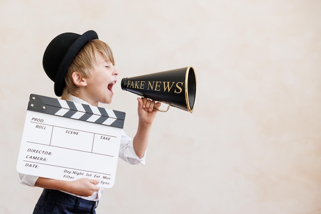 Krantenverkoper schreeuwen tegen de achtergrond van de grungemuur Jongen die nepnieuws verkoopt