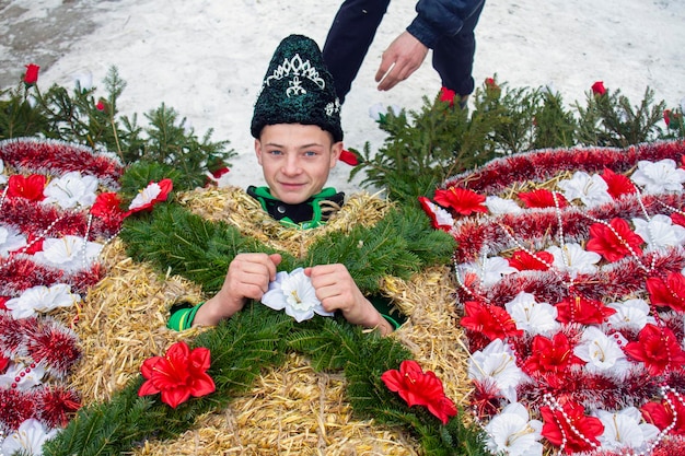 Krasnoilsk, Oekraïne, 13 jan. 2017 Een jonge jongen in een strobeerkostuum kleden op Malanka