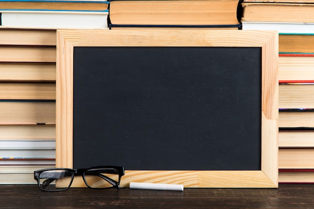 Krijtbord, glazen en krijt, tegen boeken, exemplaarruimte.