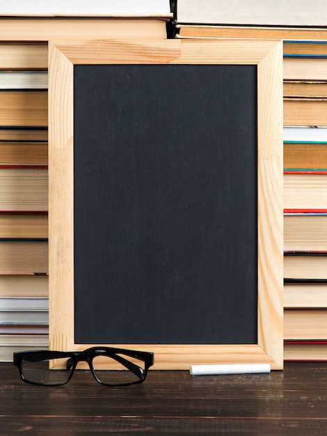 Krijtbord, glazen en krijt, tegen boeken, exemplaarruimte.