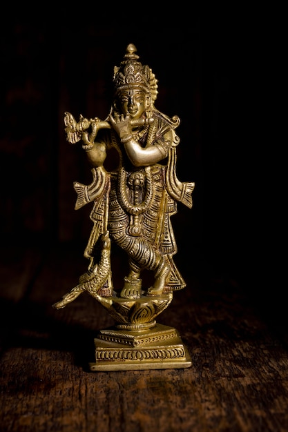 Foto krishna-standbeeld op houten achtergrond