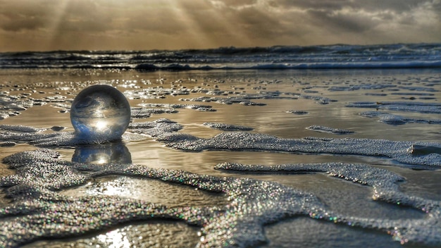 Foto kristallen bal op zee tegen de hemel tijdens zonsondergang