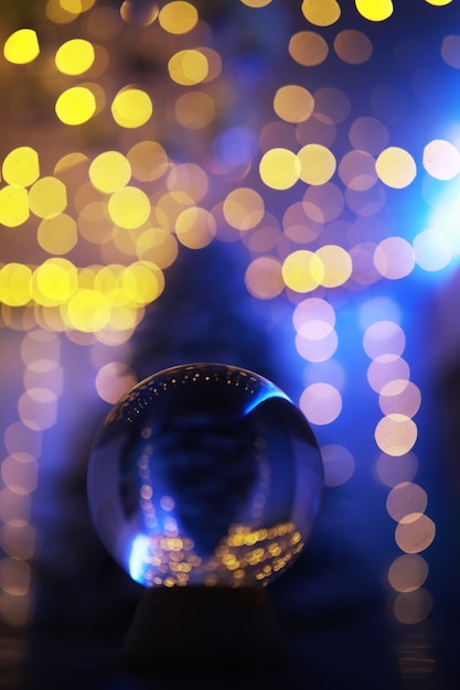 Foto kristallen bol op de vloer met bokeh, lichten erachter. glazen bol met kleurrijk bokehlicht, nieuwjaarsviering concept.