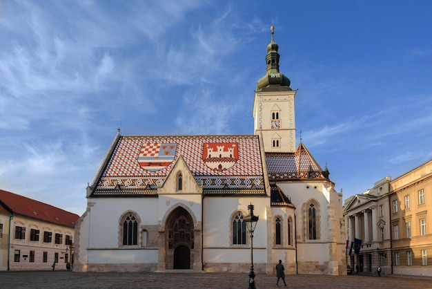 Kroatië Zagreb 29 maart 2019 Kerk van St. Mark parochiekerk met kleurrijk tegeldak in gouden avondlicht Middeleeuws gebouw met wapenschild en embleem van Zagreb is een populair bezienswaardigheid