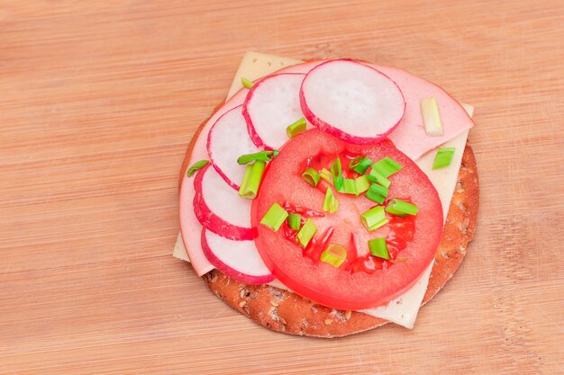 Krokant broodje cracker met tomatenworst, kaas, groene uien en radijs