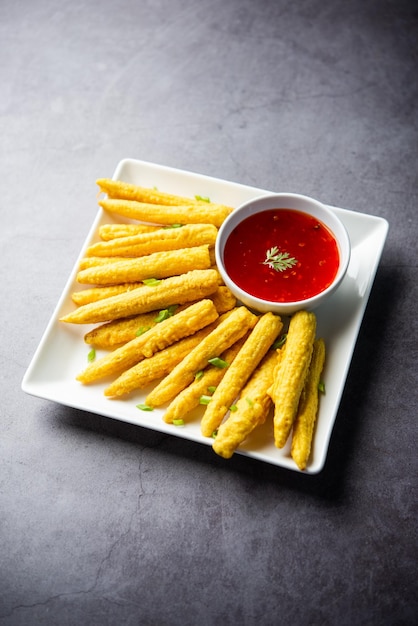 Krokant gebakken baby corn pakoda pakora of Baby corn beignets geserveerd met ketchup Indiaas eten