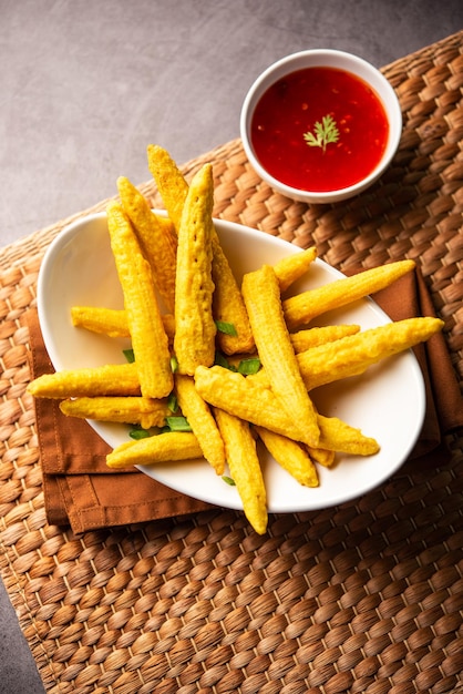 Krokant gebakken baby corn pakoda pakora of Baby corn beignets geserveerd met ketchup Indiaas eten