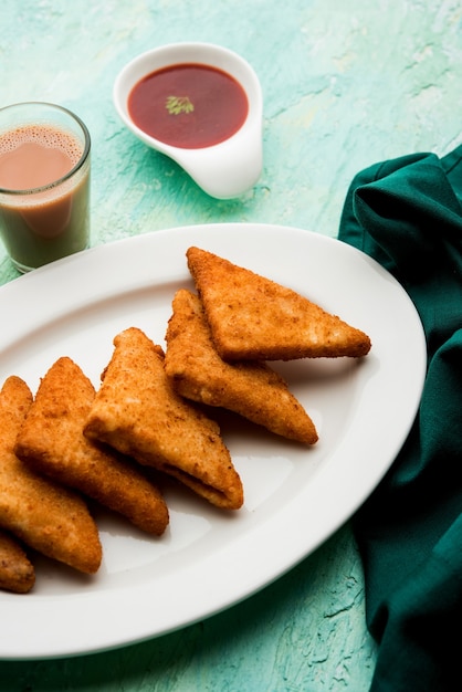 Krokante Aardappeldriehoeken of batata vada bedekt met paneermeel en daarna gefrituurd. geserveerd met tomatenketchup. selectieve focus