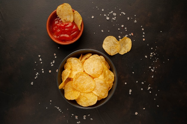 Krokante chips in een kom op een stenen achtergrond