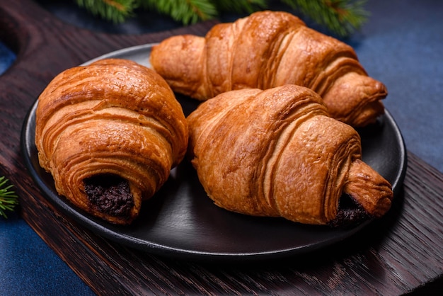 Krokante chocoladecroissant met kerstversiering op houten snijplank